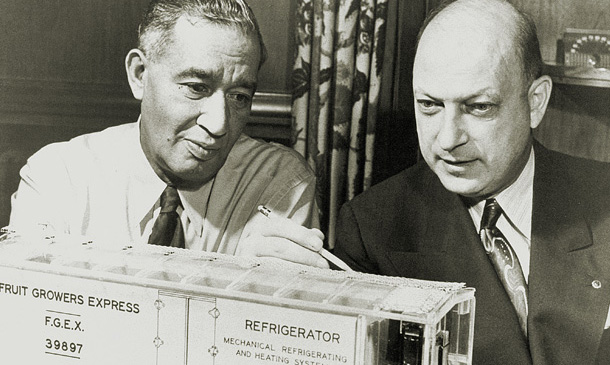 Vintage photo of Fred Jones and Joe Numero examning a model rail car.